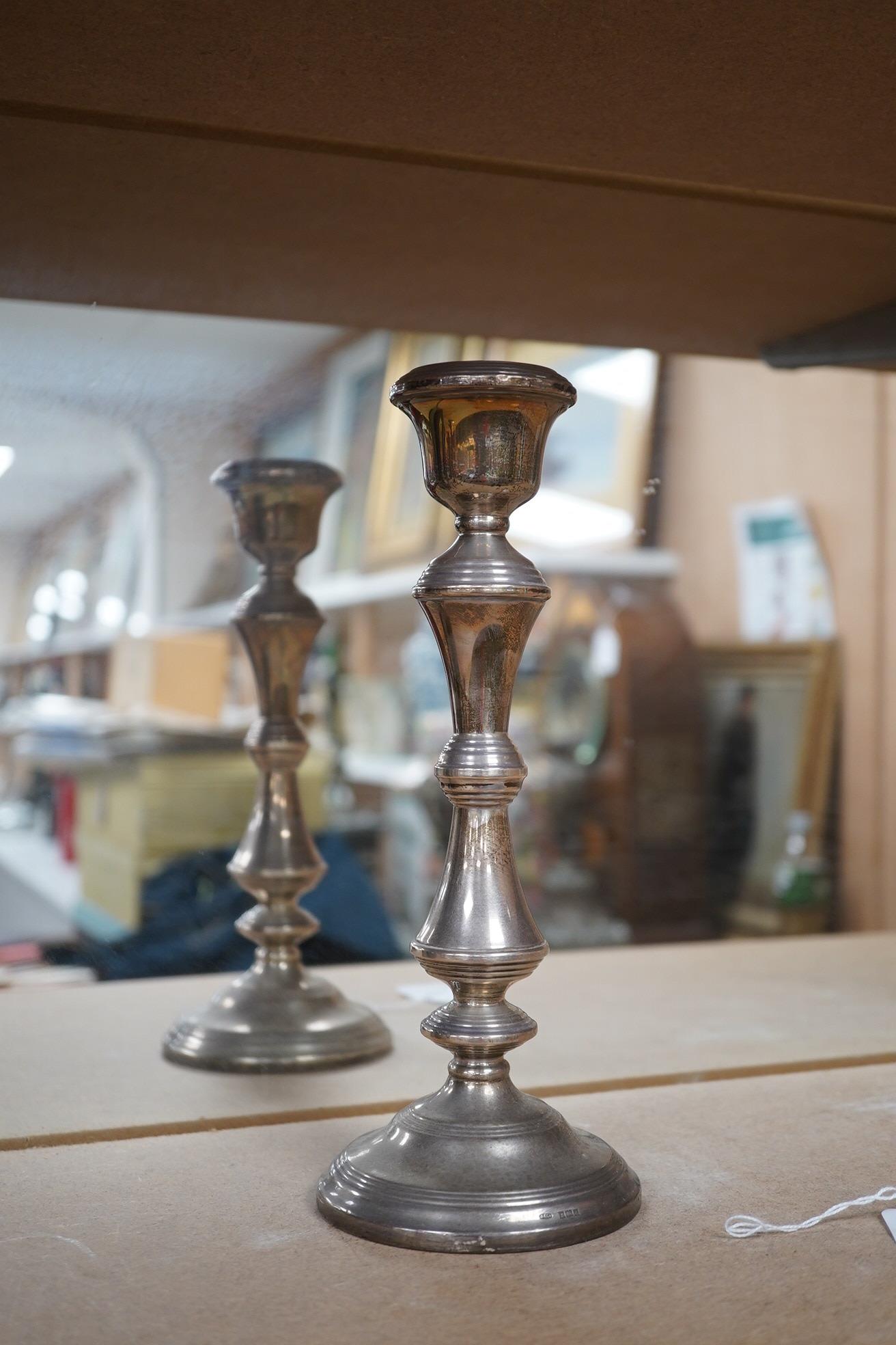 A pair of Elizabeth II silver candlesticks, Broadway & Co, Birmingham, 1960, 25.7cm, weighted, together with a similar silver three light candelabrum, by Adie Bros, weighted. Condition - poor to fair